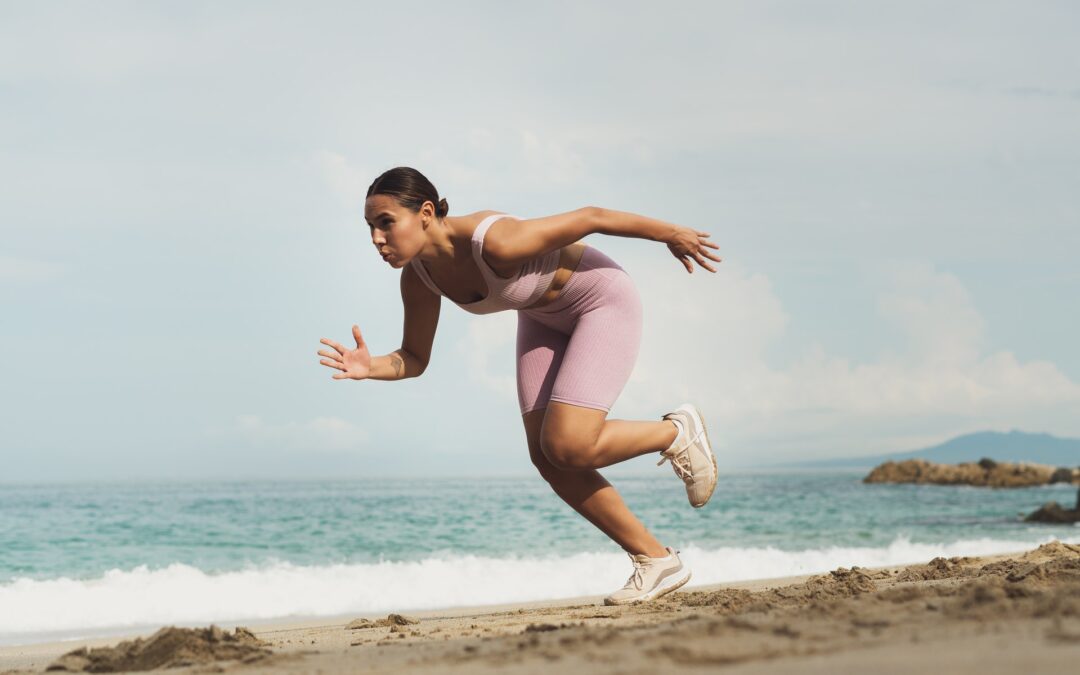 woman in pink athletic wear running on the beach