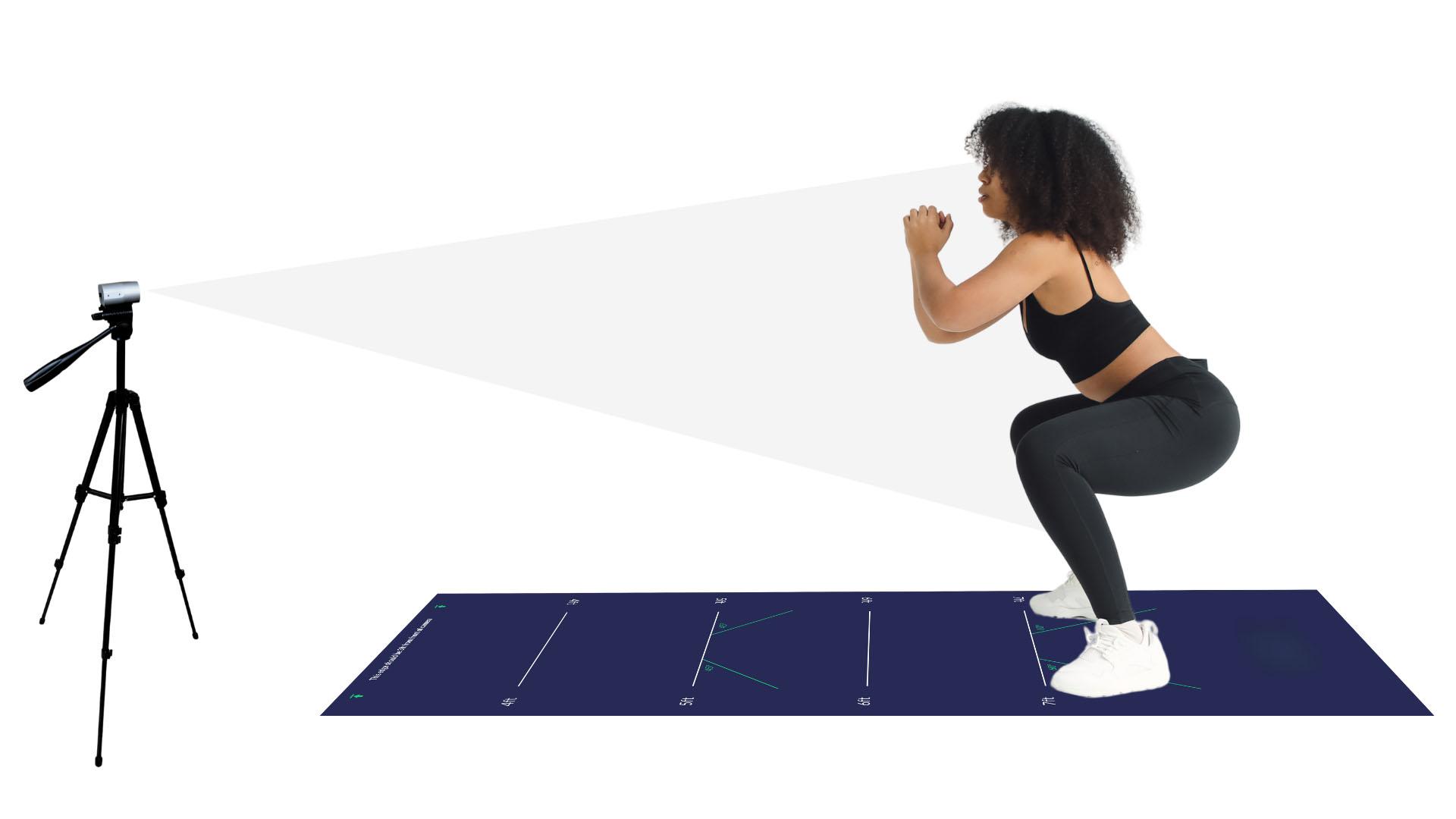 a woman in athletic wear performs a squat on a tech mat