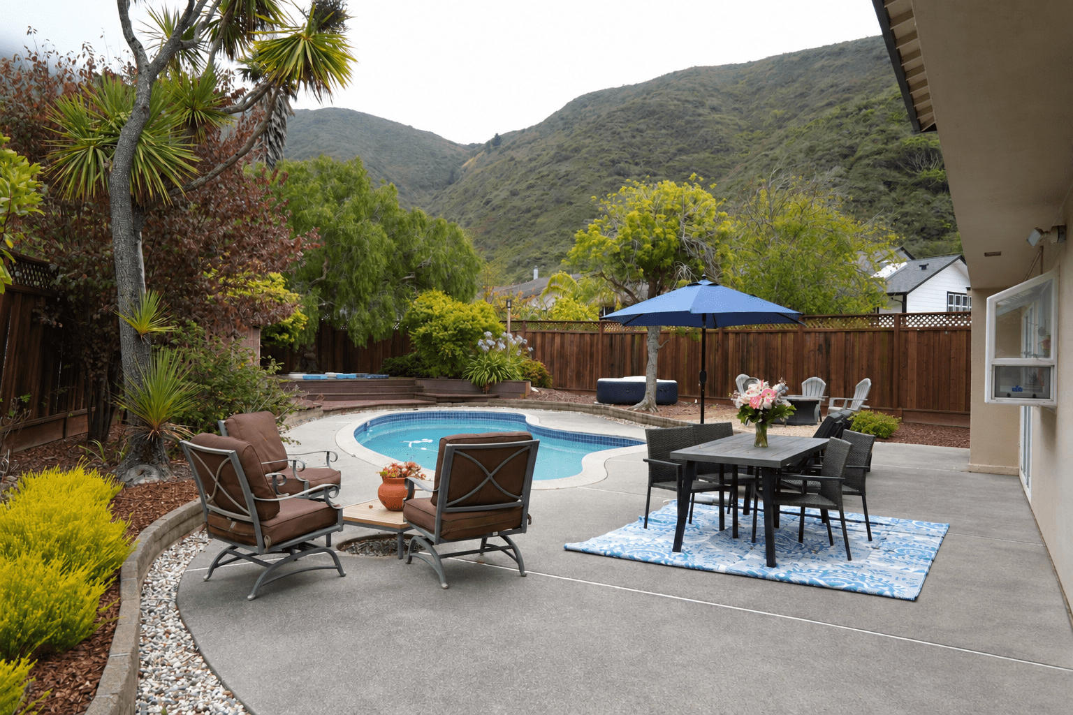 Pacifica corporate retreat setting with pool, outdoor seating, and coastal hills